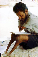 Born without hands and legs, he draws pictures to earn his living