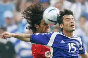 Greeces Zisis Vryzas is challenged by Portugals Fernando Couto during their Euro 2004 Group A match at the Dragao Stadium in Porto 