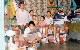 Babu Lal's family in happier times poses for a photograph with coach Gian Inder Singh at his one-room house in Shastri Hall