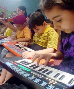Students learn playing the keyboard at a summer camp organised by Love Dale School