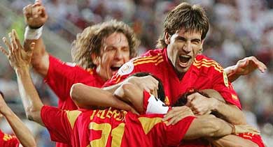 Spain's goal scorer Juan Carlos Valeron is jumped on by David Albelda and Carles Puyol