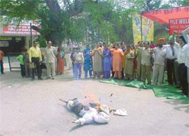Residents of P&T Colony burn an effigy of officials of the Department of Posts in protest against the shortage of water supply
