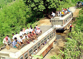 Commuters and traders travel on the roofs of packed buses