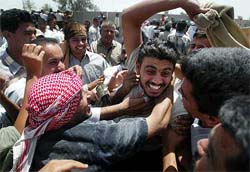 An Iraqi man jumps into the arms of his family members and friends