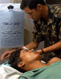 A Nepalese army officer treats a survivor of a Maoist attack