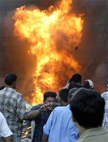 Iraqis rush to the scene of a car bomb attack in the centre of the Iraqi capital