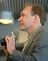 World Wide Web inventor Tim Berners-Lee holds a camera during a news conference