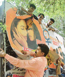 Activists of the All-India Hindu Suraksha Samiti remove posters of Girlfriend 