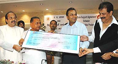 Vice-Chairman and Managing Director of Reliance Industries Anil Ambani hands over a Rs 64-crore cheque to UP Chief Minister Mulayam Singh Yadav 