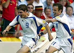 Greece's Angelos Haristeas celebrates with team-mate Themistoklis Nikolaidis after scoring against Spain during their Euro 2004 group A match