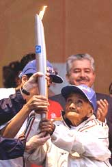Former athlete Rosario "Chayito" Iglesias, a 93-year-old holds up the Olympic torch in at the main square Zocalo in Mexico City 