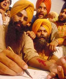 Mr Gurcharan Singh Grewal, president of the Sikh Students Federation, signs a memorandum in blood