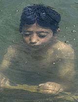A Kashmiri boy cools himself in the waters of Dal Lake
