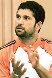 Sachin Tendulkar gestures during a news conference after attending a fitness camp in Bangalore