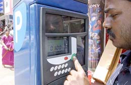 Indian driver Kodanda Pani purchases a parking ticket from one of the newly-installed parking metres at the citys busy commercial hub Brigade Road in Bangalore 