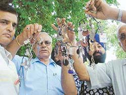Residents of Shaheed Bhagat Singh Nagar return keys of their houses to the Chairman of the Ludhiana Improvement Trust in Ludhiana on Wednesday. 