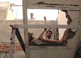An MCD employee demolishing an unauthorised construction at the Photographic Goods Market at Chandni Chowk in the Capital 