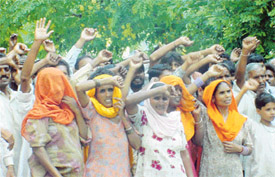 Slum-dwellers of Block E, Shaheed Bhagat Singh Nagar, raise slogans against their evacuation move in Ludhiana