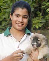 Pakistani swimmer Rubab Raza, 13, poses with her puppy in Lahore on Wednesday