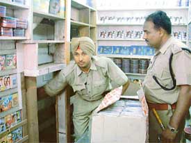 Cops show the hidden closet where duplicate CDs were stored by a shopkeeper at Bhadaur House in Ludhiana