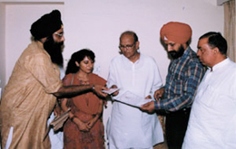 Former Prime Minister V P Singh hands over a roll of honour to Dr Jagmail Singh. 