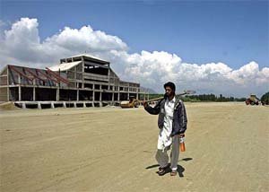 A Kashmiri labourer carries a spade