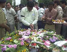 Railway officials place flowers on the coffins of an engineer and his brother