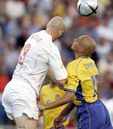 Netherlands' Jaap Stam out jumps Sweden's Henrik Larsson