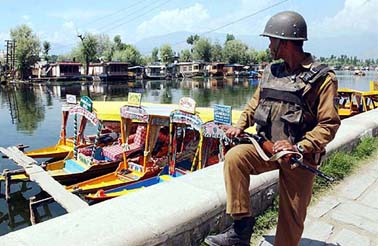 A security personnel keeps a vigil on the bank of the Dal Lake in Srinagar on Sunday. 