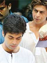 Bollywood director Karan Johar is accompanied by film star Shah Rukh Khan as they walk out of the crematorium after the funeral of Johars father