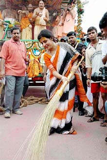Dona Ganguly, wife of Indian cricket captain Sourav Ganguly, brooms the road in front of the rath 