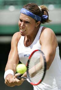 Seventh seed Jennifer Capriati of the USA reaches for a backhand return to 25th seed Nathalie Dechy of France in their match at the Wimbledon Tennis Championships