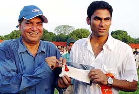 Cricketer Mohammed Kaif and his father show the house key and a cheque of rupees five lakh