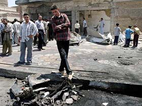 Iraqis survey the scene of twin car bombs in the city of Hilla, 100 km south of the capital Baghdad