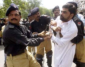 Pakistani police arrest a supporter of former Prime Minister Nawaz Sharif's party during a protest in Lahore