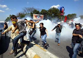 Anti-NATO activists try to escape from teargas during a demonstration in Istanbul 