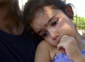 A little girl being comforted at a kindergarten yard after a rocket attack in the southern Israeli town of Sderot on Monday