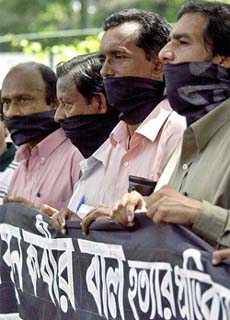 Bangladeshi journalists with their faces covered protest against the killing of Bengali newspaper editor Humayun Kabir in Dhaka