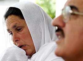 Saeeda Jehan mother of Pakistani hostage Amjad Hafeez,  weeps as the President of Pakistan- occupied Kashmir Mohammad Anwar speaks to reporters after their meeting in Islamabad