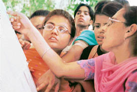Curious students and their parents check admission list outside the admission centre at Government Model Senior Secondary School