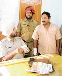 Salem Tabri SHO Buland Singh presents the accused who allegedly snatched a bag from a petrol station employee