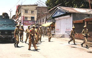 Policemen rush towards the site of the grenade explosion just before the opening ceremony of a flyover at Lal Chowk, Srinagar on Tuesday.