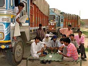 Truck drivers and cleaners play cards to pass time