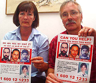 Trevor and Hillary Foster display "lookout posters" of Maninder Pal Singh Kohli, the suspected killer of their daughter, Hannah, during a Press conference in Chandigarh on Wednesday.