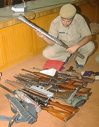 A policeman shows a cache of arms seized from a ‘dera’ of Nihangs in Amritsar on Tuesday.