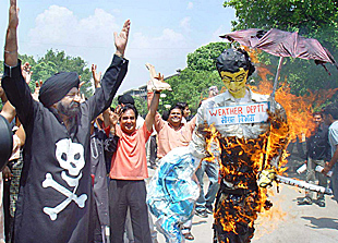 Jaspal Bhatti and his Nonsense Club members burn the effigy of the Met Department to appease the rain god in Chandigarh on Wednesday.