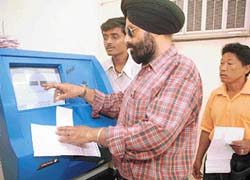 A power consumer pays his bill through a machine installed at the Punjab State Electricity Board office in Mohali on Tuesday.