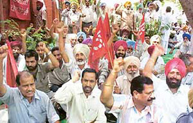 Members of the PRTC Workers Union hold a dharna in front of the PRTC headquarters in Patiala
