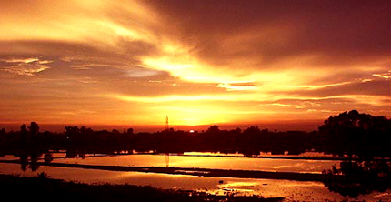 Nature's fury blends with its beauty as the sun set is reflected in all its glory in the receding flood waters near Rajpura