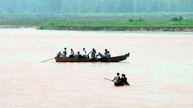 People cross the Sutlej by a boat near Mattewara village